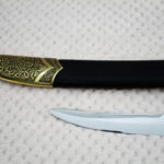 Close-up of the SiCh-Souvenir black scabbard tip with floral and spiral ornament