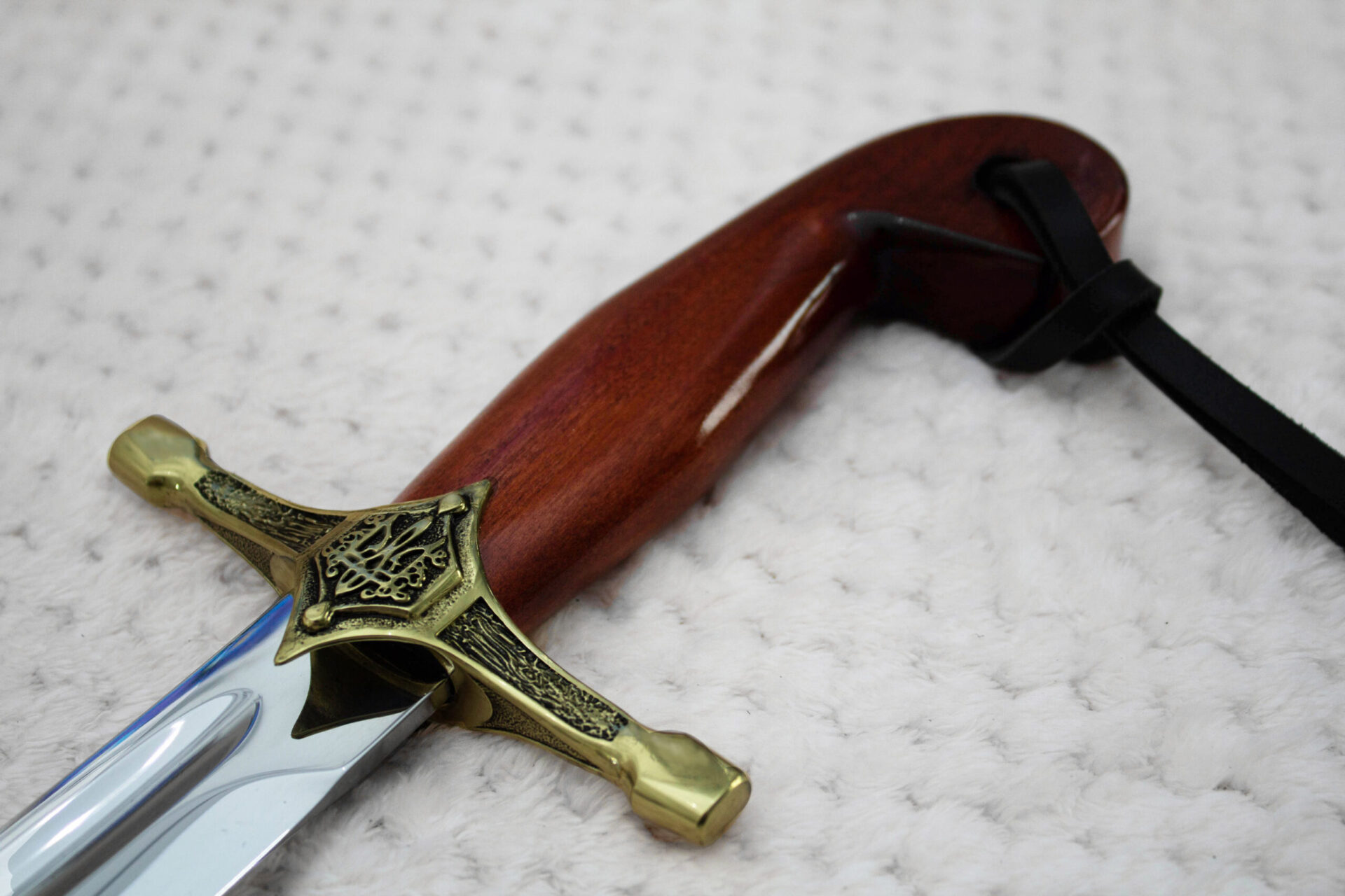 SiCh-Souvenir saber grip close-up with reddish-brown grain, trident-decorated guard and black tassel strap