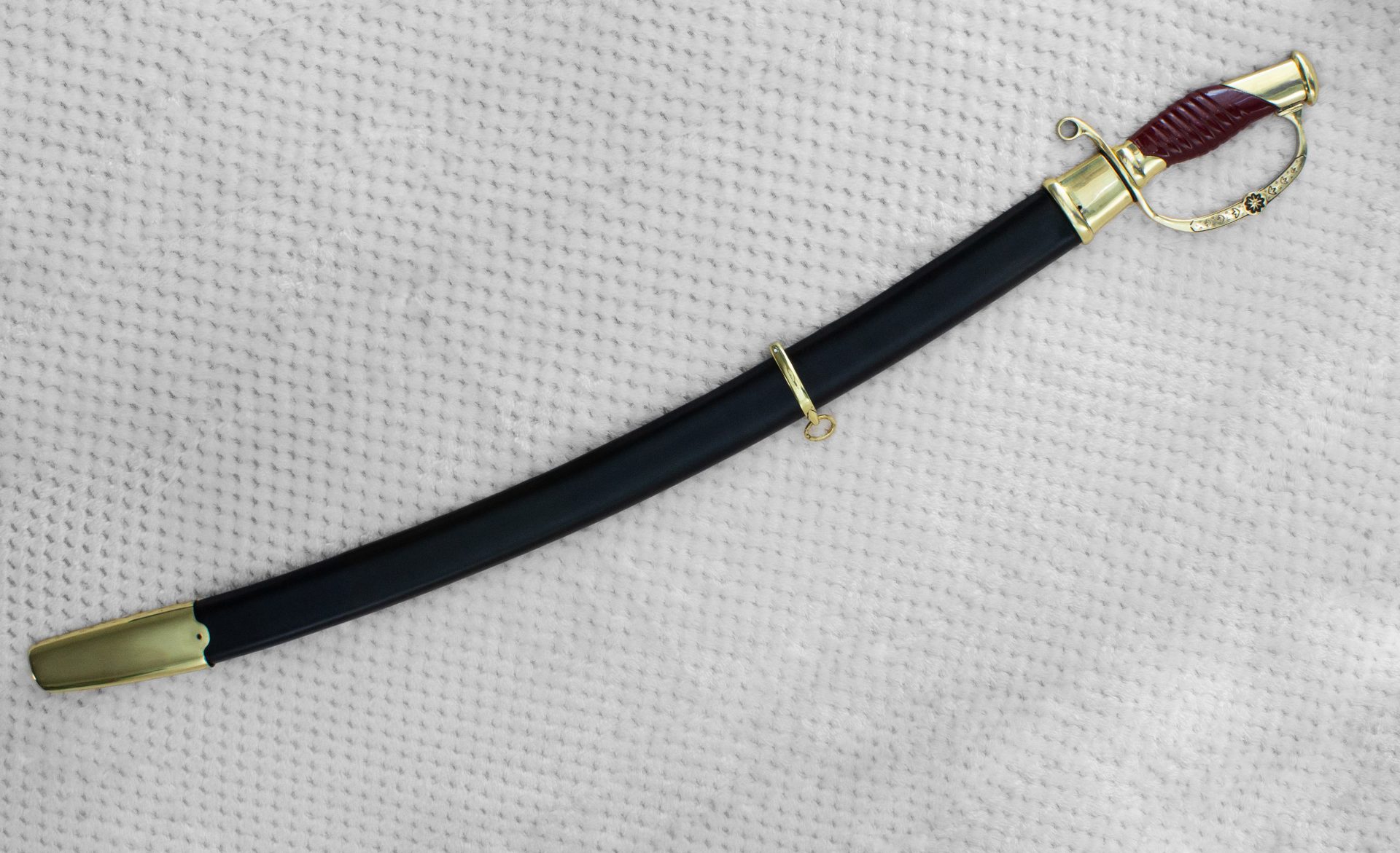 Dragoon saber in a black scabbard with metal fittings and a suspension ring