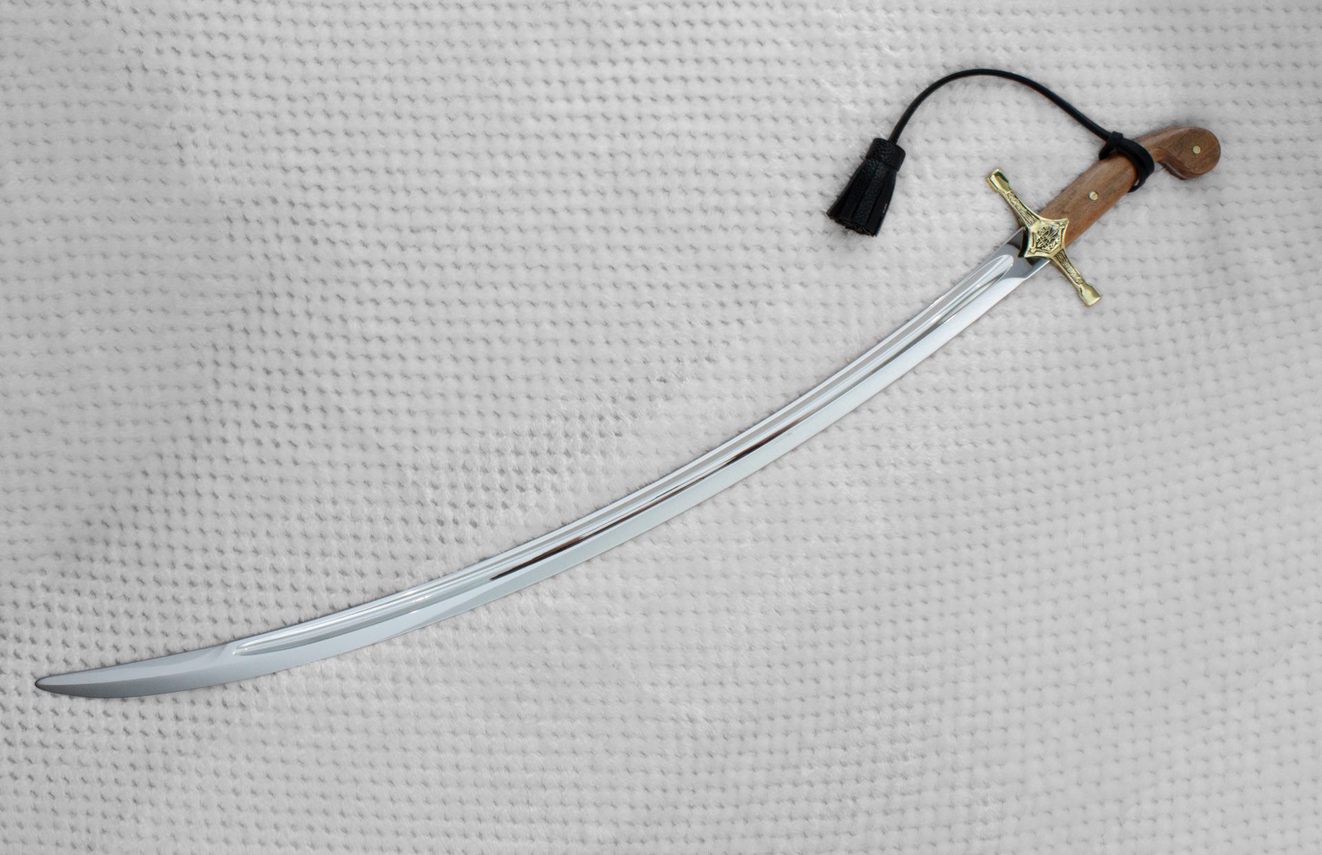 Curved SiCh-K saber blade with a long fuller and brown grip, viewed at an angle