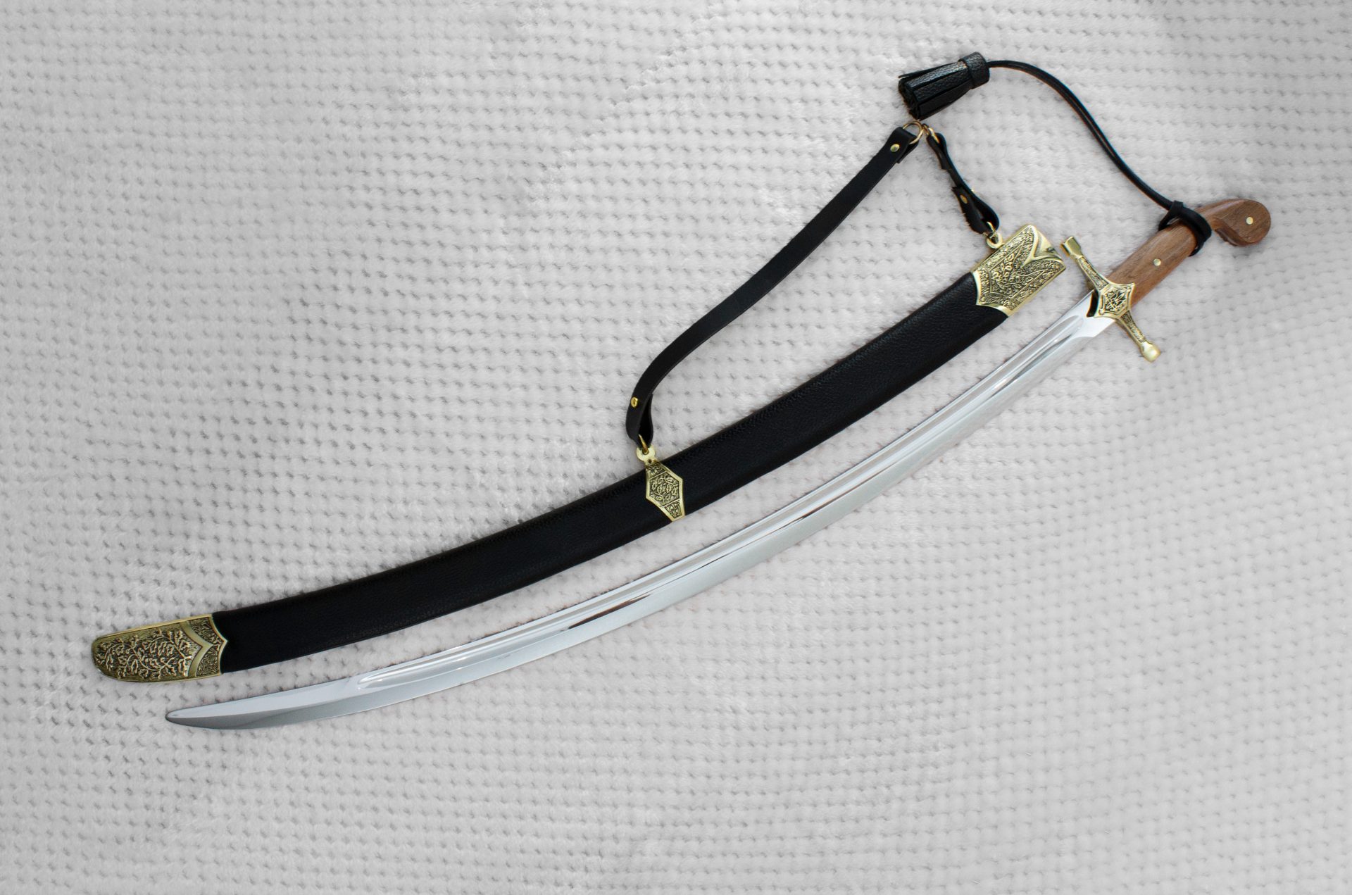SiCh-K saber beside its black scabbard and suspension strap, viewed from the tip